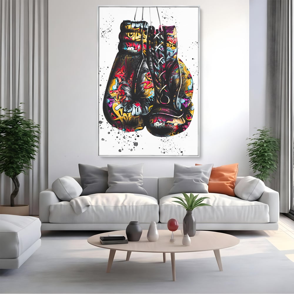 Tablou canvas cu tablou canvas cu manusi de box, in rama de aluminiu argintiu, pe perete intr-un living